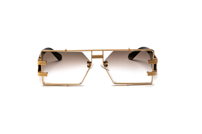 Front-angle product image of black buffalo horn sunglasses from Vintage Wood Collection, featuring 24-karat gold detailing and gradient brown lenses. The sunglasses have a sleek, street-style design and are displayed on a clean white background.